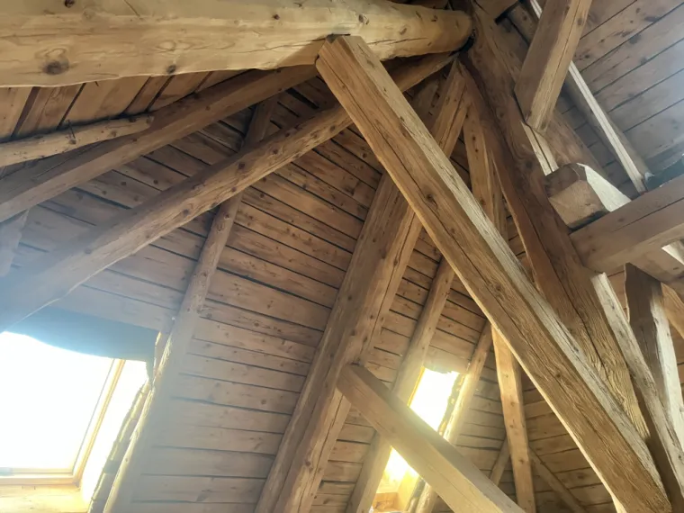 Préparation du sablage intérieur de charpente dans le Jura par Mazzetti Aérogommage. Nettoyage et décapage complet du bois avant rénovation.