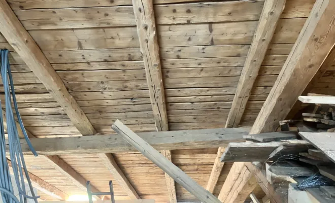 Sablage intérieur de charpente bois ancienne – Mazzetti Aérogommage, expert du Jura en restauration et nettoyage professionnel du bois.